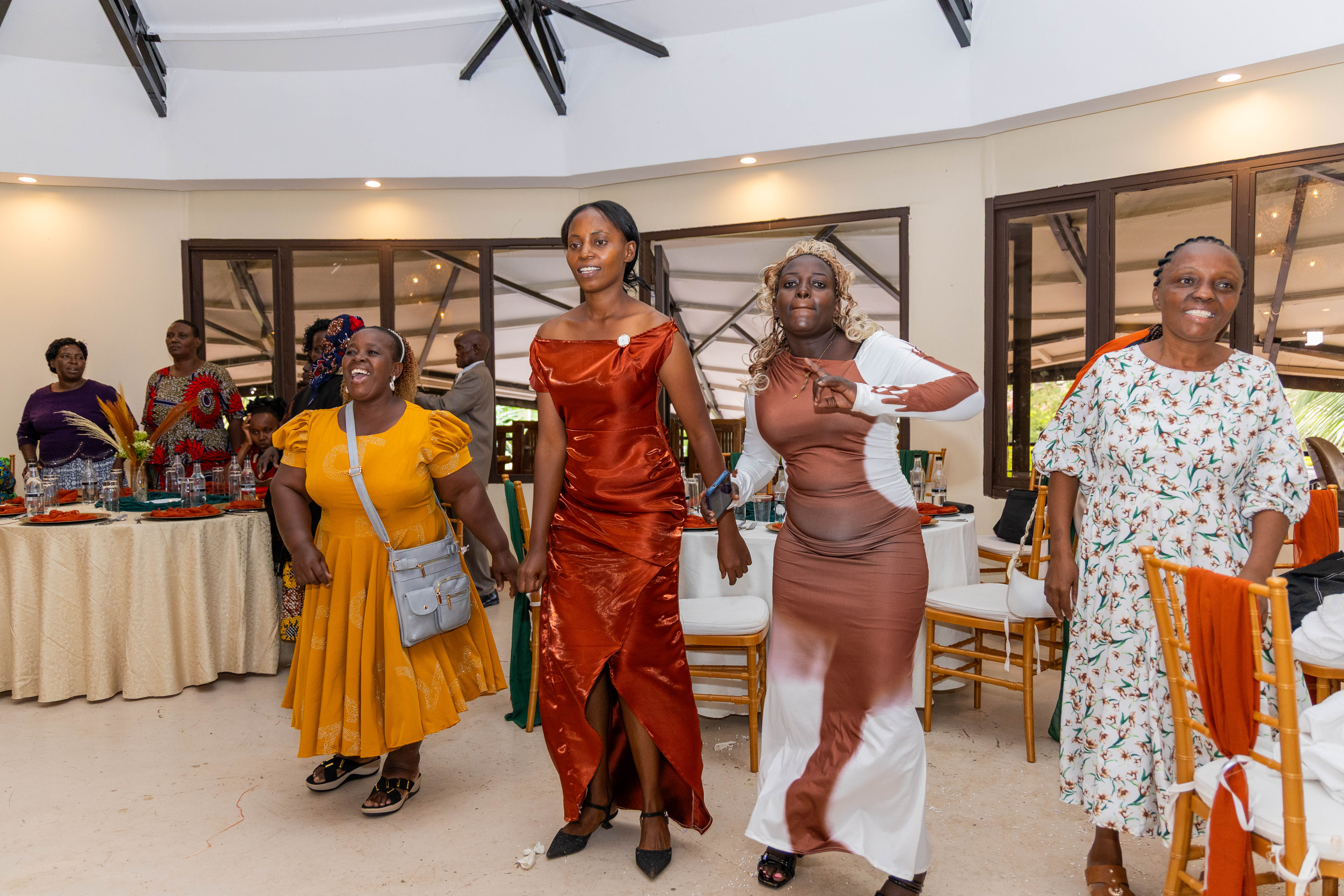 Guests in colourful dresses dance between the reception tables